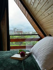 a bed with a tray of flowers on it with a window at Andezit Kazbegi in Kazbegi