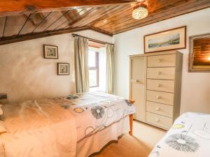une chambre avec un lit, une commode et une fenêtre dans l'établissement Chenalls Cottage, à Helston