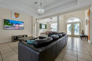 a large living room with a large leather couch at Salty Pool Escape - Nearby Beach in Palm Coast
