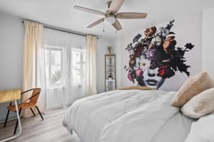 ein Schlafzimmer mit einem Bett mit einem Gemälde eines Gesichts in der Unterkunft Urban Spanish Bungalow in San Diego