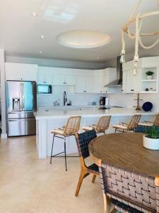 a kitchen with a table and chairs and a kitchen with white cabinets at BEACH FRONT CONDO, PRIVATE BEACH and AMAZING VIEWS!! in Los Cuatro Hermanos