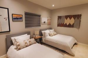 a bedroom with two beds and a window at BEACH FRONT CONDO, PRIVATE BEACH and AMAZING VIEWS!! in Los Cuatro Hermanos +20 photos