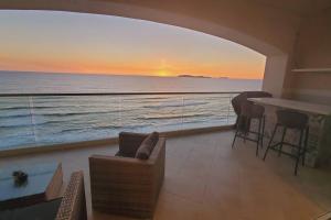 a living room with a view of the ocean at BEACH FRONT CONDO, PRIVATE BEACH and AMAZING VIEWS!! in Los Cuatro Hermanos