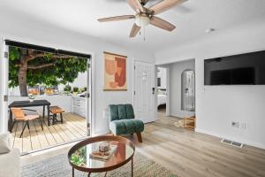 ein Wohnzimmer mit einem Deckenventilator und einem Tisch in der Unterkunft Urban Spanish Bungalow in San Diego