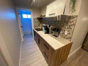 a kitchen with a sink and a counter top at Brand New Modern Flat 2br1ba Whyte And University in Edmonton