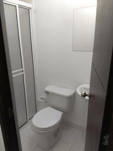 a white bathroom with a toilet and a shower at occidente Santa Fe de Antioquia sol y playa in Santa Fe de Antioquia