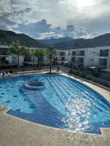 a large blue swimming pool in front of a building at occidente Santa Fe de Antioquia sol y playa in Santa Fe de Antioquia