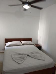 a bedroom with a bed with a bow tie on it at occidente Santa Fe de Antioquia sol y playa in Santa Fe de Antioquia +10 photos