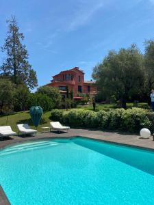 Una piscina con sillas y una casa al fondo. en Charming Villa, en Mougins
