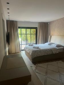 Un dormitorio con una cama y una ventana grande en Charming Villa, en Mougins