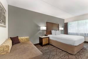 a hotel room with a bed and a couch at Best Western Plus Longbranch Hotel & Convention Center in Cedar Rapids