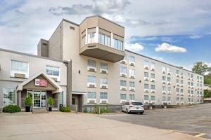 a building with a car parked in a parking lot at Best Western Plus Longbranch Hotel & Convention Center in Cedar Rapids