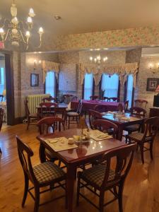 a restaurant with tables and chairs in a room at Cranberry Cove Inn in Louisbourg +32 photos