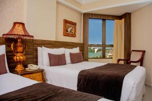 a hotel room with two beds and a window at Majestic Ponta Negra Beach,WorldHotels Elite in Natal