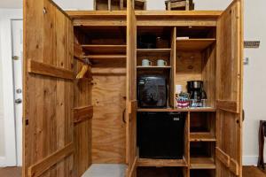 a wooden pantry with a small black refrigerator at #17 The Texas House at Garrison in Gruene in New Braunfels