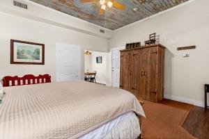 a bedroom with a bed and a wooden cabinet at #17 The Texas House at Garrison in Gruene in New Braunfels