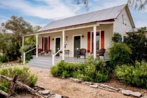 a small white house with red doors and a porch at #17 The Texas House at Garrison in Gruene in New Braunfels
