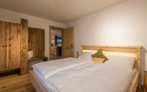 a large white bed in a room with wooden walls at Maurlechnhof in Lutago