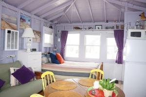 a small room with a table and a bed at Peaceful Waterfront Beach Cottage! in Truro
