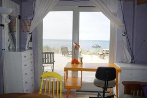 a room with a desk and a window with a view of the beach at Peaceful Waterfront Beach Cottage! in Truro