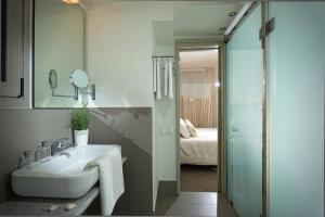 a bathroom with a sink and a glass shower at Skajado Holiday Apartments in Stalís +37 photos