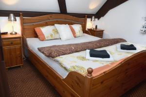 a bedroom with a wooden bed with two towels on it at Hotel Jiřičná in Sušice