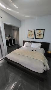 a bedroom with a large bed with two pictures on the wall at The Concept in Centurion +54 photos