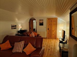 a living room with a brown couch and wooden floors at The Viewpoint in Newry