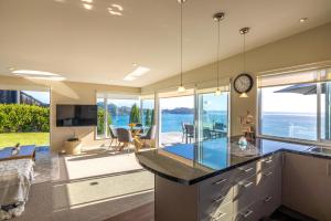 a kitchen with a view of the ocean at Onetangi Clifftop, Onetangi - Be My Guest Waiheke in Onetangi