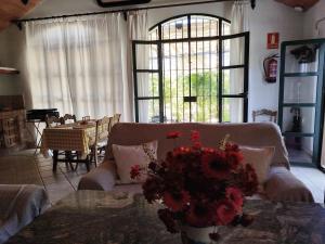 a living room with a couch and flowers on a table at Casa Rural del Guadalora in Hornachuelos