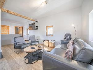 a living room with a leather couch and chairs at Chalet Adriana in Kirchberg in Tirol