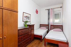 a bedroom with two twin beds and a dresser at Apartments with a parking space Pirovac, Sibenik - 13201 in Pirovac