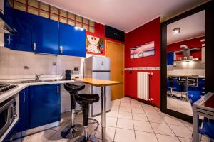 a kitchen with blue and red cabinets and a counter at Cozy Suite Rogoredo Apartment next to the metro and train station in Milan
