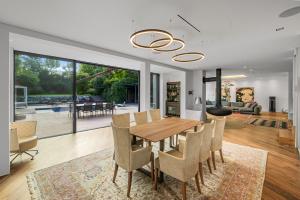 a dining room and living room with a table and chairs at Majestic Poolside Villa with Jacuzzi, Pool, Panoramic Views in Brunn am Gebirge