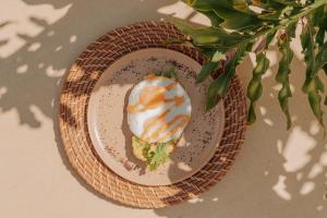 a plate of food with a egg on a table at Hotel Tahiti in Puente Iglesias