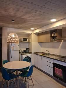 a kitchen with a table and a table and chairs at Depto Los Pinos in Ostende