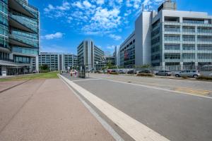 an empty street in a city with tall buildings at Cozy Suite Rogoredo Apartment next to the metro and train station in Milan +31 photos
