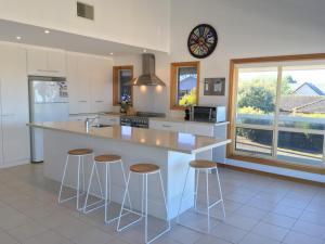 a kitchen with a large island with bar stools at Breezes at Hayborough - Coastal beach house and pet friendly in Hayborough