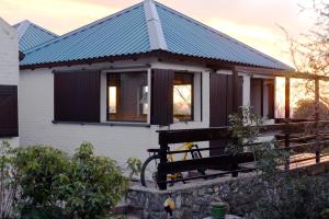 a small white house with a blue roof at Púrpura Atardecer Hermosa casa de montaña in San Javier