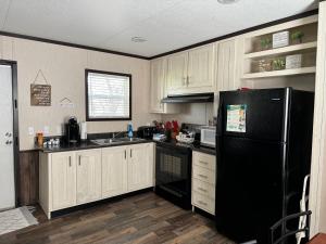 a kitchen with white cabinets and a black refrigerator at Casita on the Ranch 2 in Spring Branch