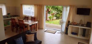 a living room with a table and a kitchen with a sliding glass door at Muri Pittman Sunrise in Titikaweka