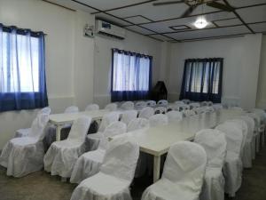 a conference room with a long table and white chairs at Sevens Hideaway Beach Resort in Siaton