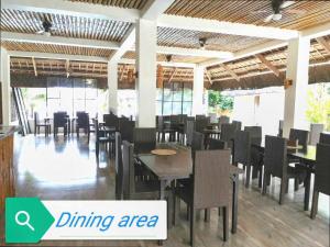 a dining area with tables and chairs in a restaurant at Sevens Hideaway Beach Resort in Siaton