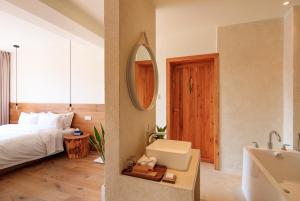 杭州Hangzhou Moju Boutique Guesthouse at the West Lake的带床、水槽和镜子的卧室