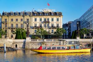 a yellow boat in the water in front of a building at Hotel d'Angleterre in Geneva