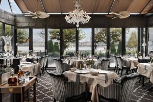 ein Restaurant mit Tischen und Stühlen und einem Kronleuchter in der Unterkunft Hotel d'Angleterre in Genf