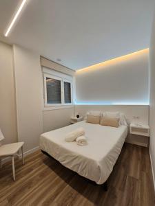 a bedroom with a large white bed and a window at Rest Pedrouzo in O Pedrouzo