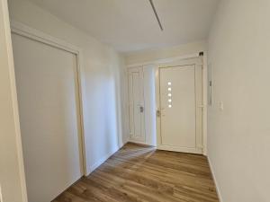 an empty hallway with white walls and wooden floors at Rest Pedrouzo in O Pedrouzo