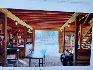 a wooden house with a table and a motorcycle inside at Alderbrook Yurt in Warrensburg