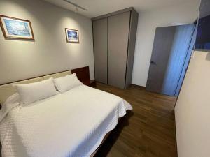 a bedroom with a white bed and a door at Equipetrol Depto 1 Dorm piso 12 in Santa Cruz de la Sierra +17 photos